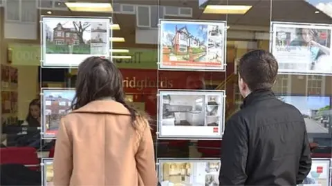 Getty Images People looking in estate agents window