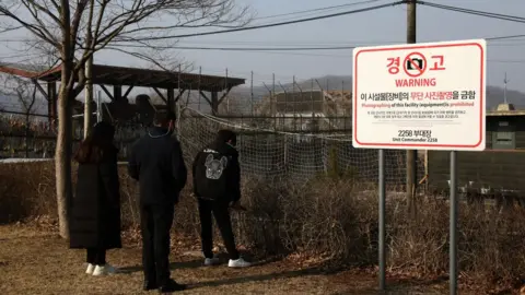 A North Korean defector family pay tribute to ancestors at a spot near the DMZ border