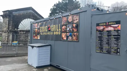 Takeaway in a shipping container in front of a large fanned window