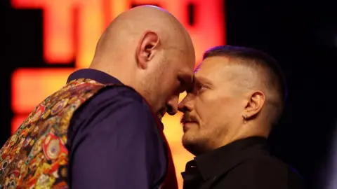 Tyson Fury puts his forehead to Oleksandr Usyk's during a face-off
