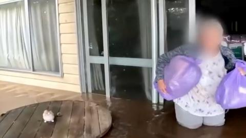 Elderly woman rescued from floodwaters by emergency rescue teams