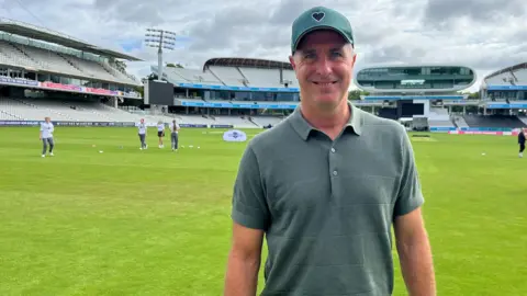 Michael Vaughan wearing a cap and green T-Shirt