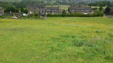 A field with some houses in the background 