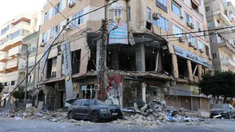 AFP Damaged building following an Israeli strike targeted a branch of the Hezbollah-linked Al-Qard Al-Hassan financial association in the southern Lebanese city of Tyre (21 October 2024)