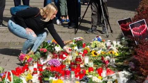 Ying Tang/NurPhoto A memorial is set near the entrance of the attack site and in front of Solingen City Church for locals who bring flowers and candles and write messages after the Solingen attack