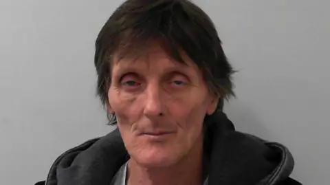 North Yorkshire Police A man with dark hair and a dark-coloured hoodie pictured against a grey background.
