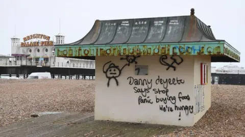 Getty Images Graffiti on a hut on Brighton beach with the pier in the background