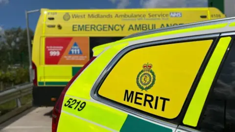 West Midlands Ambulance Service A medical car is pictured in front of an ambulance on a sunny but cloudy day.