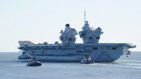 PA Royal Navy aircraft carrier HMS Prince of Wales sets sail from Portsmouth Harbour