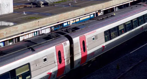 A Cross Country train at Wolverhampton Railway Station. The train can be seen from an elevated walkway, on a sunny day.