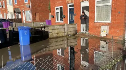 The garden of a house submerged in floodwater
