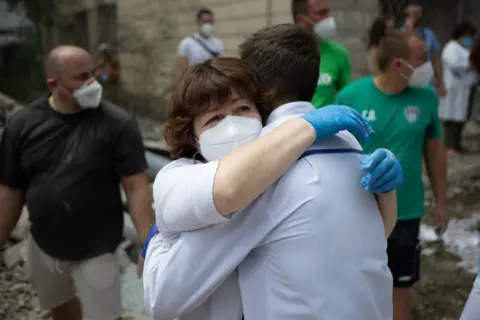 Healthcare workers embrace after the strike in Kyiv