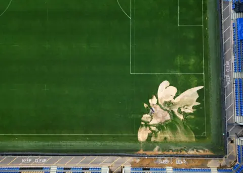 Hannah McKay/REUTERS A drone view of a sink hole caused by heavy rainfall at the Cherry Red Records Stadium, home of AFC Wimbledon football club in London, Britain, September 23, 2024. 