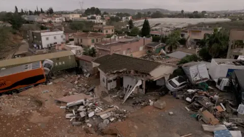 The home of the Matías family was partially destroyed. Some roofs are broken and some walls are missing. It is surrounded by trash and debris, as well as cars and trucks