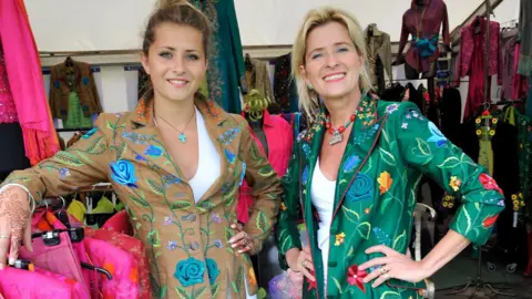badminton horse trials Cheltenham based Beatrice Von Trecksow's stand at Badminton shows two of the stand ladies in colourful jackets which they sell