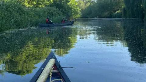 A view of people on a kayay on a river 
