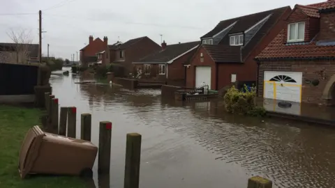 Flooded street with houses on either side