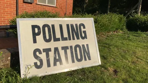 A black and white sign reads 'polling station