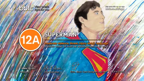 Superman, drawn in his iconic blue, red, and yellow costumer. He is emerging from a background of multicoloured streaks. The word 'Superman' and an orange circle around the digits '12A' overlays the design.