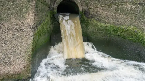 Brown effluent from a Welsh Water discharge pipe