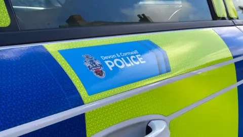 A fluorescent panel of a police car which has the Devon and Cornwall Police logo on it.