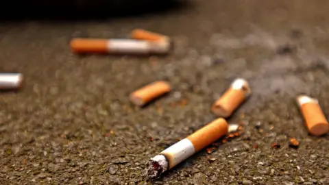 Press Association Discarded cigarette butts on road