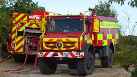 Dorset & Wiltshire Fire and Rescue Service two fire engines parked in a country area.