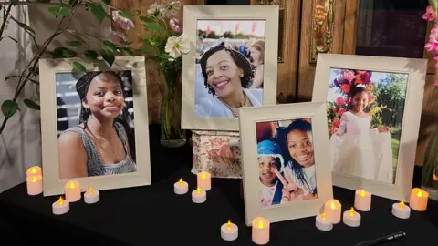 Sam Read/BBC Framed pictures from a memorial for a mother and her two daughters, surrounded by battery-powered candles