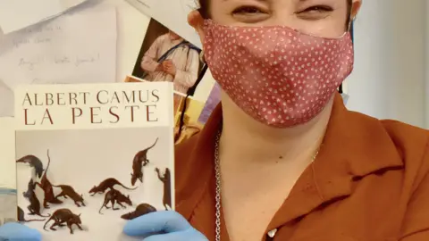 A bookseller with a copy of The Plague (La Peste) in Italy