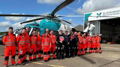 Doctors, paramedics and pilots from KSS standing in front of a helicopter 