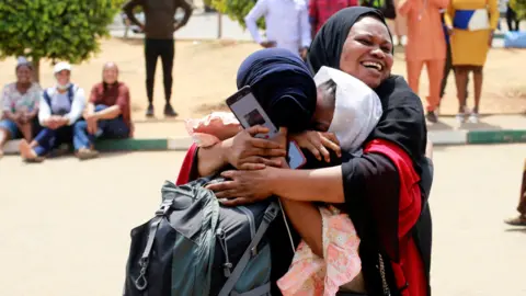 Reuters Women hugging - one recently returned from Ukraine - in Abuja, Nigeria - Friday 4 March 2022