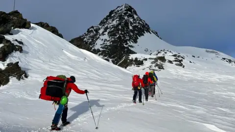 Bergrettung Kals Mountain rescue teams walk through the snow in Austria