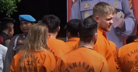 BBC A group of people wearing orange prison suits