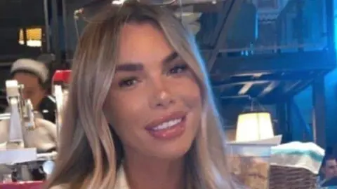 Handout Ashley Dale smiles at the camera while sitting in a restaurant