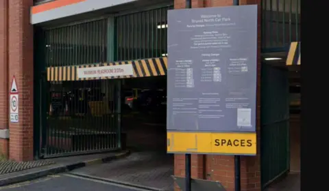 Local Democracy Reporting Service The entrance to a car park with a yellow sign which says 'Spaces'
