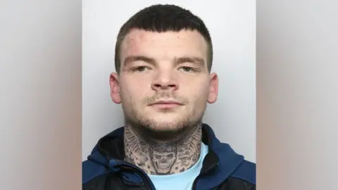 A police custody image of Brandon Brooks, sporting a skull tattoo on his neck