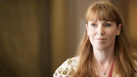 PA Media Deputy Prime Minister Angela Rayner with her hair down and wearing a cream patterned dress