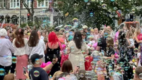 Reuters  Bubble blowing event held in Southport - crowds surrounded by bubbles look into the sky