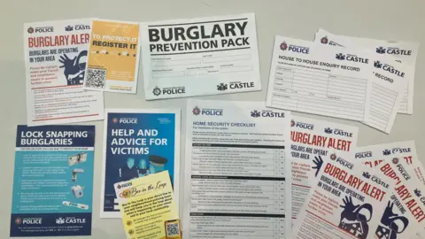 Photograph of the leaflets which are handed out to victims of burglary in Greater Manchester