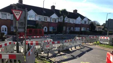 Local Democracy Reporting Service The image shows road closures in front of a row of houses.