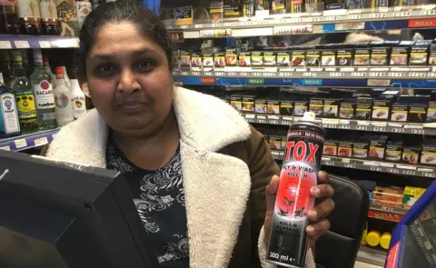 BBC Shiyam Gunawardena holding a can of wasp killer