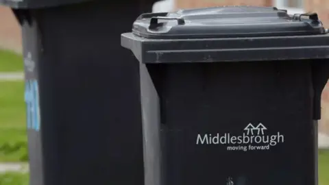 A black wheelie bin with the words "Middlesbrough moving forward" in white on it.