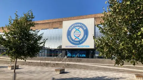 Martin Heath/BBC Metal and glass frontage of school building with Northampton International Academy sign