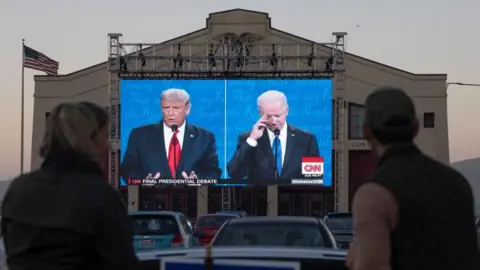 Getty Images Viewers watch a 2020 presidential debate between Joe Biden and Donald Trump. The two will likely face off again in the 2024 US presidential election.