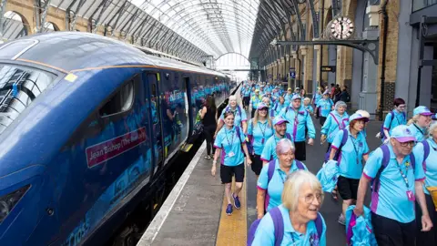 Hull volunteers wearing blue shirts on the platform at London's Kings Cross railway station