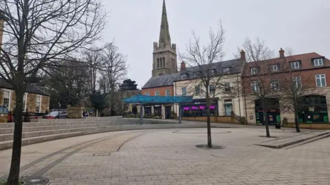 A view of a town centre market place. It is clean and tidy but there are no people in it.