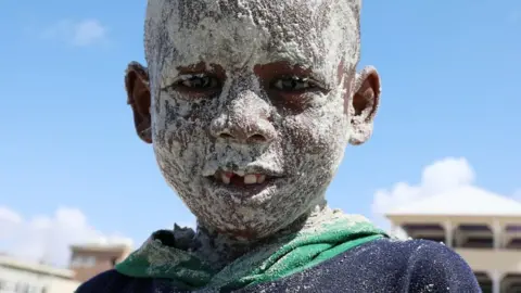 A Somali boy covers his face with sand at the Liido Beach during the last Friday ahead of the Muslim holy month of Ramadan, amid the coronavirus disease (COVID-19) pandemic in Mogadishu, Somalia April 9, 2021.