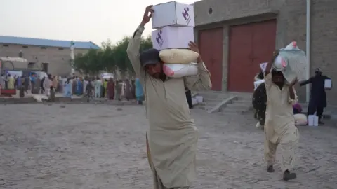 Human Appeal Men carrying aid supplies in Pakistan