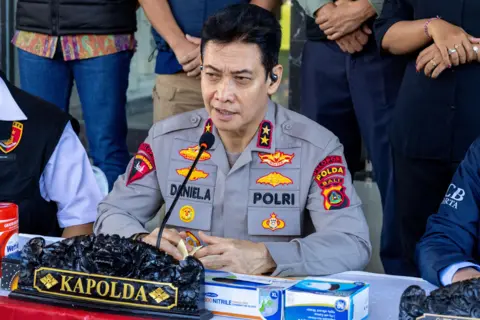 EPA Bali Regional Police Chief Daniel Adityajaya - who is wearing a grey shirt with several colorful patches - speaks during a press conference on the arrest of a Scottish national at the Bali Police headquarters in Denpasar, Bali