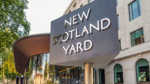 The triangular New Scotland Yard sign in front of offices in London